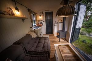 a living room of a tiny house with a couch and a stove at Miły Młyn in Lubrza