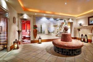 eine Lobby mit einem Brunnen in der Mitte eines Zimmers in der Unterkunft Hotel Barbarahof Superior - Adults Only in Kaprun
