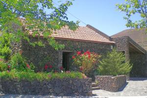 a stone house with flowers in front of it at Casa Rural Aborigen Bimbache in San Andrés