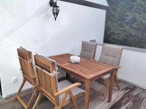 einen Holztisch und Stühle auf dem Balkon in der Unterkunft Pusteblume in Groitzsch