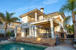 a house with a swimming pool and palm trees at Villa Sol Felostal in Palma de Mallorca