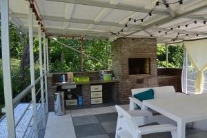 a patio with a table and a stone fireplace at Guest House at Lesya Ukrainka in Truskavets
