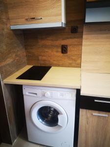 een wasmachine onder een aanrecht in een keuken bij Studio- Krasi in Varna