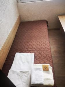 een klein bed met twee lakens en een doos erop bij Studio- Krasi in Varna