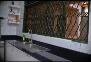 a kitchen counter with a sink and a window at Nile Estates Villa Kiwatule in Kampala