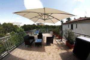 un patio con mesa, sillas y sombrilla en Rooms & Breakfast La Filigrana, en Fabriano