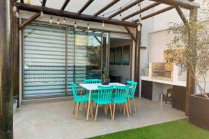 a patio with a table and chairs and a kitchen at Espectacular casa en bahía inglesa! in Bahia Inglesa