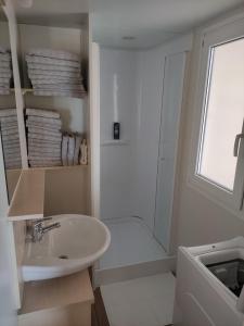 biała łazienka z umywalką i prysznicem w obiekcie K9 Mobile Home Camp Imperial Vodice w mieście Vodice