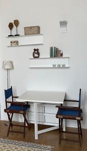 una mesa blanca y 2 sillas en una habitación en n°21 (Casa di Anna), en Copertino
