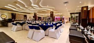 阿姆利则Hotel Makhan Residency的宴会厅配有白色和蓝色的桌椅