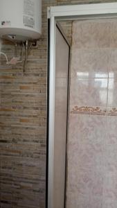 um chuveiro com uma porta de vidro na casa de banho em La Toscana em Rocha
