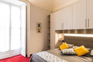 Un dormitorio con una cama con almohadas amarillas y una ventana en Hotel Alpi Resort, en Turín