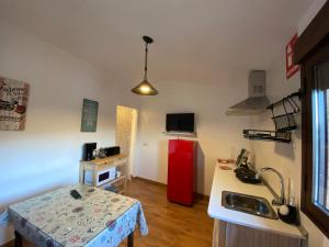 a kitchen with a red refrigerator in a room at Casas Rurales Prunus avium in Caminomorisco