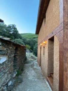 a path between two buildings with a mountain in the background at Casas Rurales Prunus avium in Caminomorisco