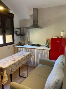 una cucina con un tavolo e un frigorifero rosso di Casas Rurales Prunus avium a Caminomorisco Altre 32 foto