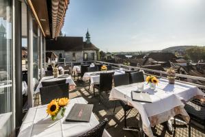 a patio with tables and chairs on a balcony at Hotel Roter Turm in Solothurn