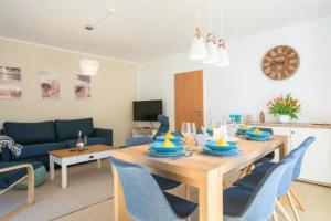 sala de estar con mesa y sillas azules en Ferienhaus Sanddorn Breege- zwischen Bodden & Meer, en Breege