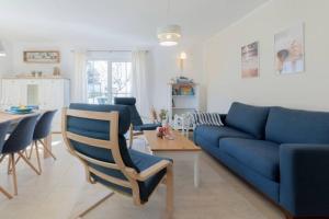 sala de estar con sofá azul y mesa en Ferienhaus Sanddorn Breege- zwischen Bodden & Meer, en Breege