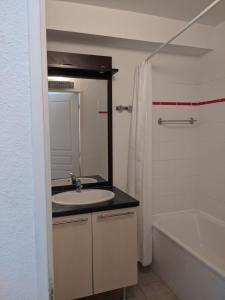 ニヨンにあるMaisonnette dans domaine avec piscine à Nyons, pays des olivesの洗面台、浴槽、鏡のあるバスルーム