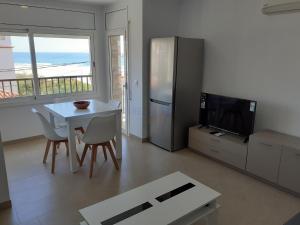 un soggiorno con tavolo bianco e frigorifero di Apartamentos Dins Mar Apto. 5 a Torredembarra