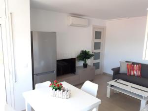 ein Wohnzimmer mit einem weißen Tisch und einem Sofa in der Unterkunft Apartamentos Dins Mar Apto. 5 in Torredembarra