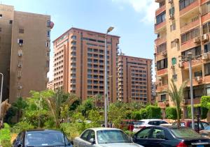 a group of cars parked in front of tall buildings at Luxury Apartment City stars in Cairo