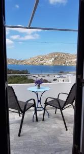 una mesa y sillas en un patio con vistas al océano en Helios Pension, en Ios Chora