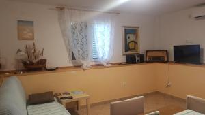 a living room with a couch and a table and a window at Gita in Omišalj
