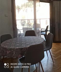 a dining room table and chairs with a table and a window at Apartman CENTAR NEVA in Trebinje