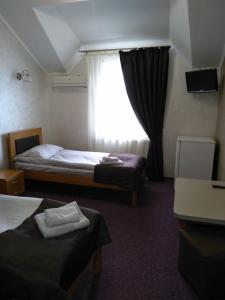 um quarto de hotel com duas camas e uma janela em VIZIT em Stryi