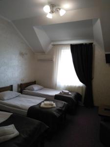 ein Hotelzimmer mit 2 Betten und einem Fenster in der Unterkunft VIZIT in Stryi