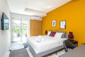 ein Schlafzimmer mit einem großen Bett und einer gelben Wand in der Unterkunft Stayhere Rabat - Agdal 2 - Classic Residence in Rabat