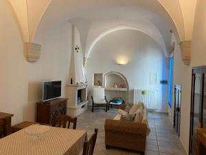 Una sala de estar con un sofá y un televisor. en CASA DIAMANTIK, en Martina Franca