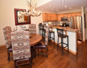 Una cocina con suelo de madera y una mesa con sillas. en Aspenwood Lodge #304 Condo, en Edwards