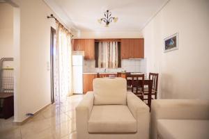 a living room with a white couch and a kitchen at VILLA KAROLINA Tsogkas in Syvota
