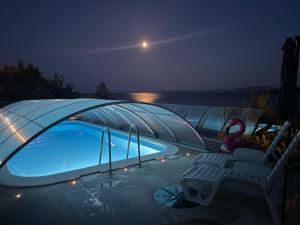 a swimming pool in a iguana tent at night at Villa Desiree in Prizba