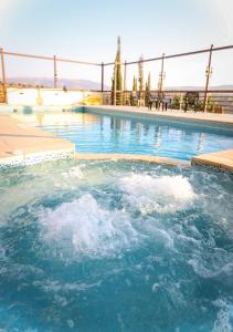 een groot zwembad met blauw water bij Sultana Farm - Private Pool Villa near Amman in Bayyūḑah