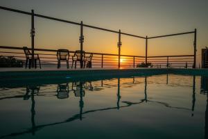 een groep stoelen bij een zwembad bij zonsondergang bij Sultana Farm - Private Pool Villa near Amman in Bayyūḑah