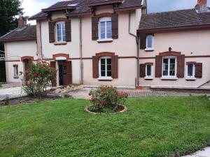 a house with a yard with flowers in front of it at Chambre d'hôtes LE PUITS DARCY in Montceau-les-Mines