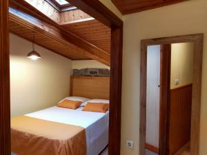 Schlafzimmer mit einem Bett und einem Spiegel in der Unterkunft Senda Verde do Salnés in Portas