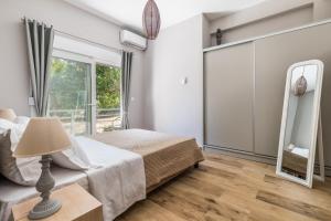 a bedroom with a bed and a mirror at Artemis' Garden in Skopelos Town