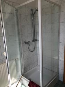 a bathroom with a shower with a bath tub at Kapitänshaus Scharmberg, Ferienwohnung Möwe in Born