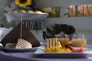 a table with two plates of food and two glasses of orange juice at La Fenice rooms in San Domino