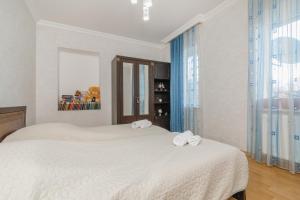 Habitación blanca con 2 camas y toallas. en Alvani Inn en Nizhniy Alvani
