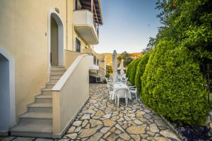 a stone walkway with tables and chairs next to a building at VILLA KAROLINA Tsogkas in Syvota