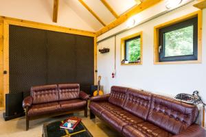 a living room with two leather couches at Casuta cu atelier in Râşnov