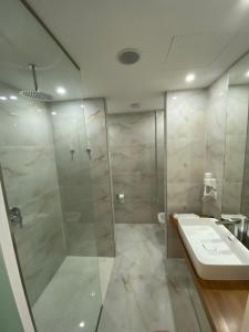 a bathroom with a shower and a sink and a toilet at Kanes Boutique Hotel in Sarandë