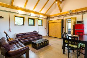 a living room with leather furniture and a table at Casuta cu atelier in Râşnov