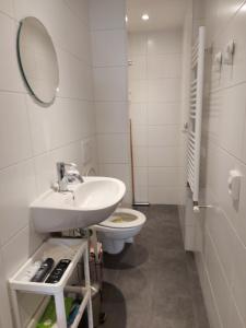 La salle de bains est pourvue d'un lavabo, de toilettes et d'un miroir. dans l'établissement B&B Margriet, à Lemmer