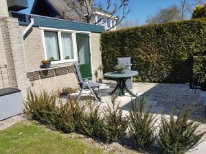 a patio with a table and a chair in front of a house at B&B Margriet in Lemmer